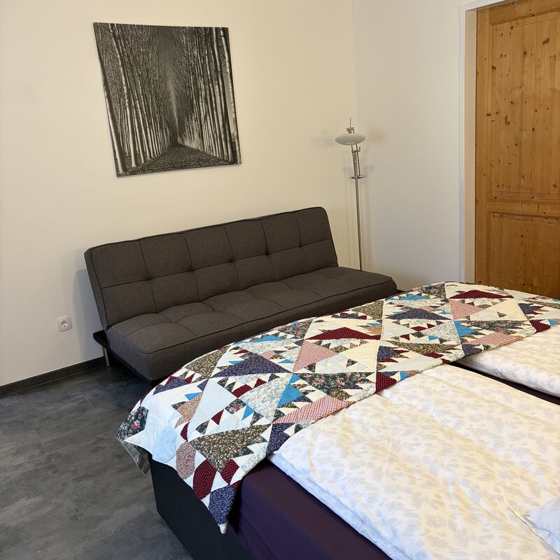 Schlafzimmer mit 2x2m Boxspringbett und Schlafcouch in der Wohnung Dost im Langerhof, Hannersdorf, Suedburgenland